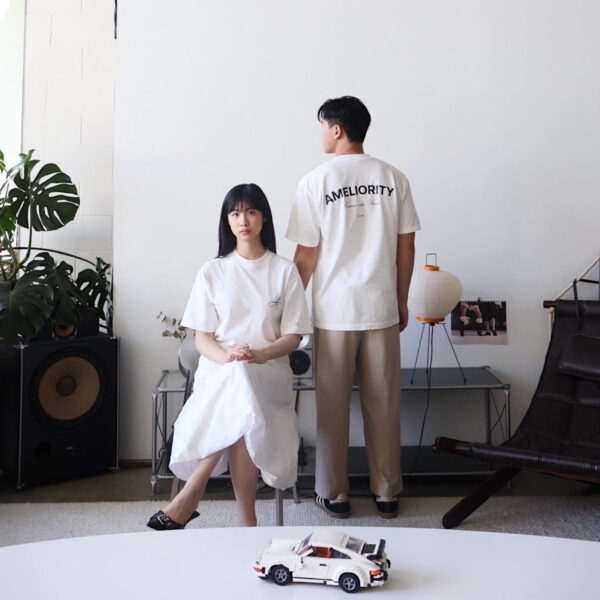 Model wearing off white oversized tee in bright neutral-toned studio space