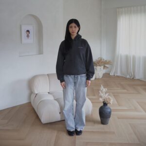 Female model wearing vintage black hoodie with loose fit in a minimal interior